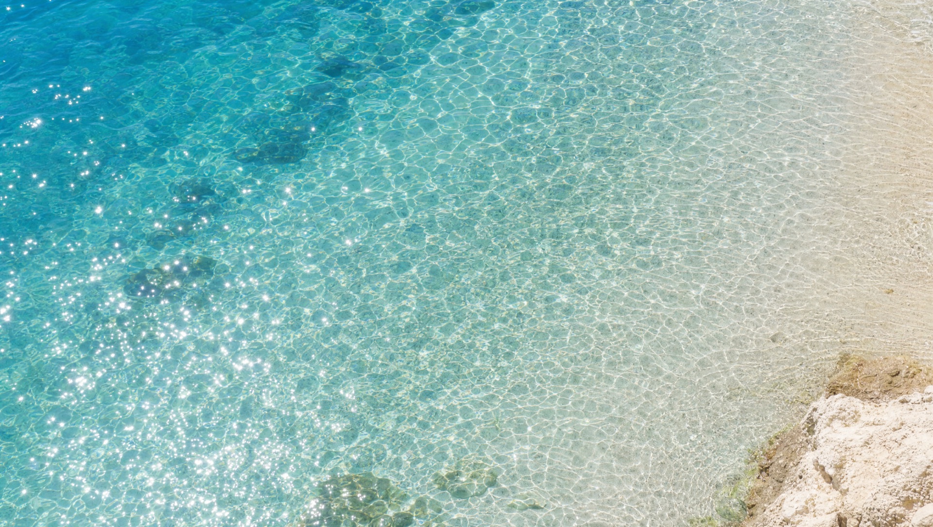 Clear turquoise sea water over white sand